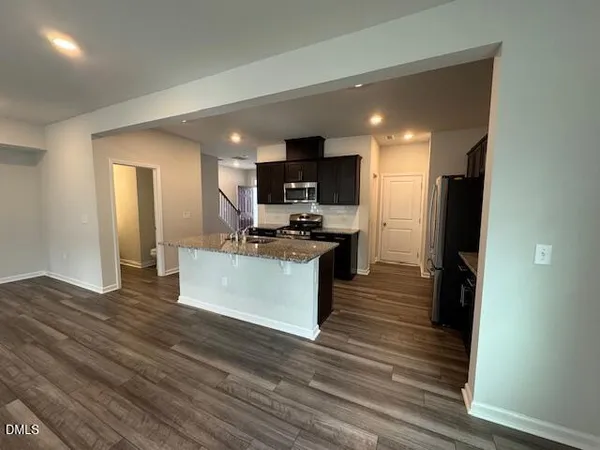 a kitchen with stainless steel appliances kitchen island granite countertop a stove and a refrigerator