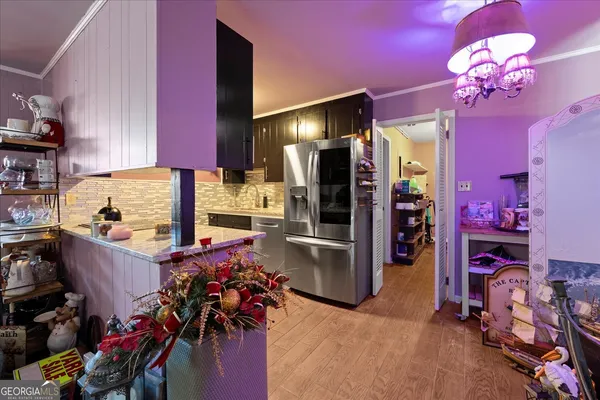 a kitchen with granite countertop a refrigerator dining table and chairs