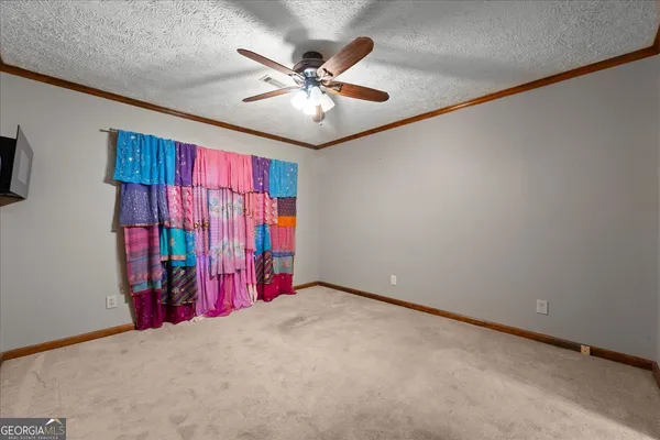 an empty room with windows and fan