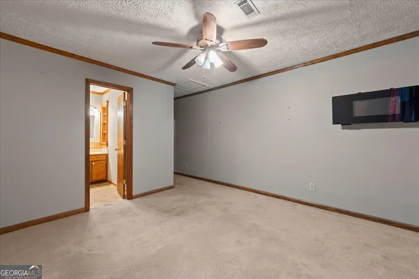 an empty room with fan and windows
