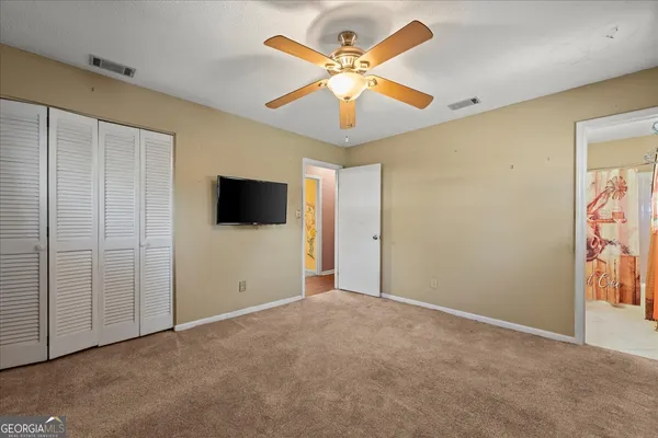 an empty room with window and a ceiling fan