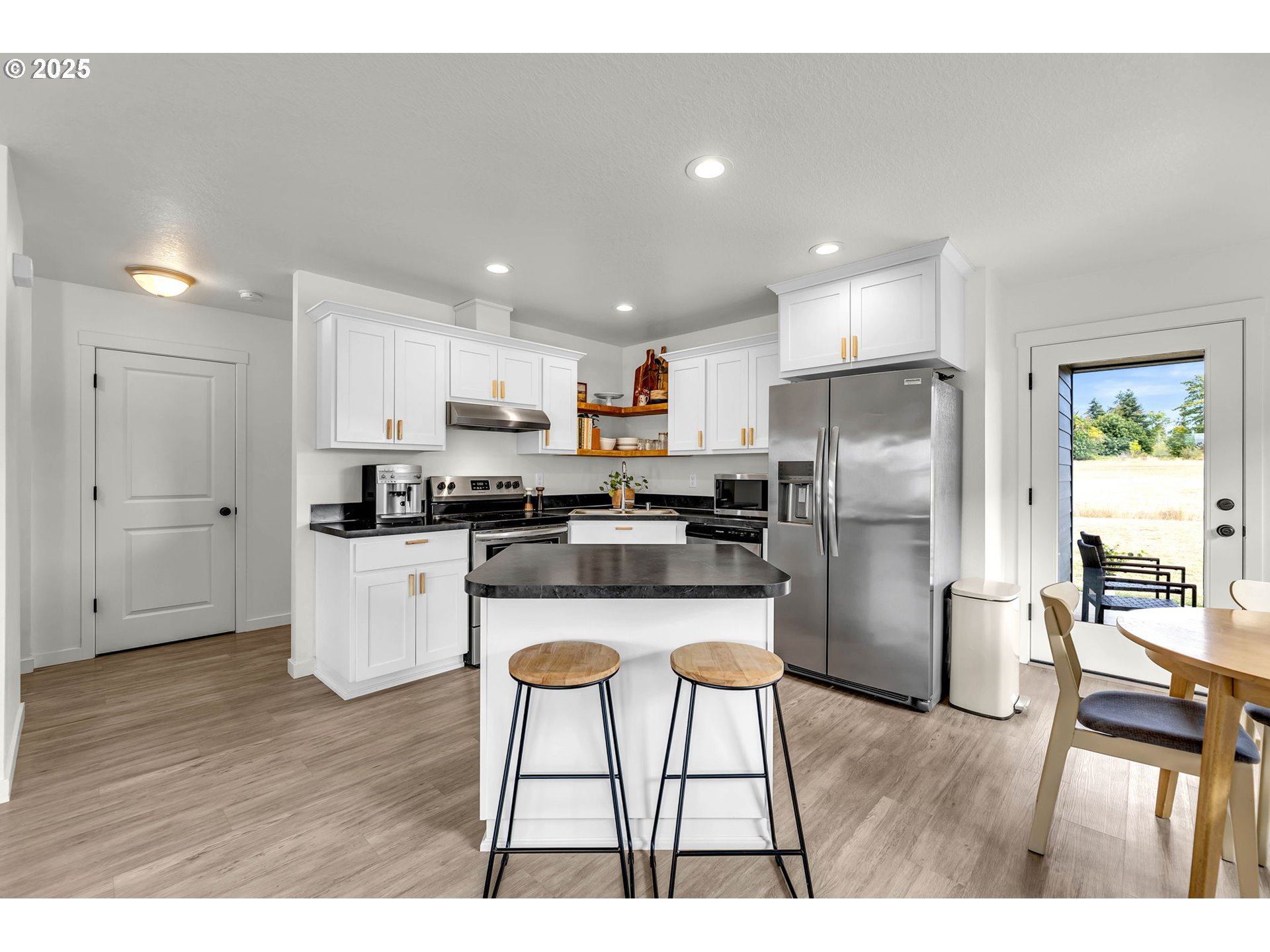 502 Cardinal Avenue Winlock, WA 98596 - Photo 10 of 33 a kitchen with a refrigerator a sink dishwasher a stove and white cabinets with wooden floor
