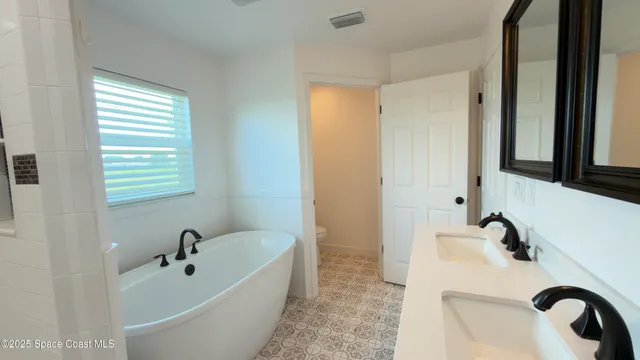 a bathroom with a tub a sink and a window