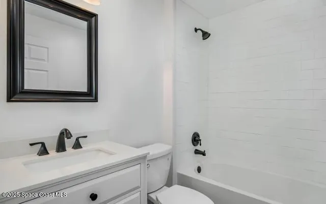 a bathroom with a toilet a sink a mirror and vanity