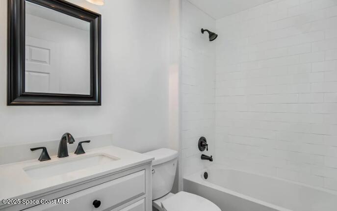 1837 Ardmore Street Northeast Palm Bay, FL 32907 - Photo 18 of 23 a bathroom with a toilet a sink a mirror and vanity