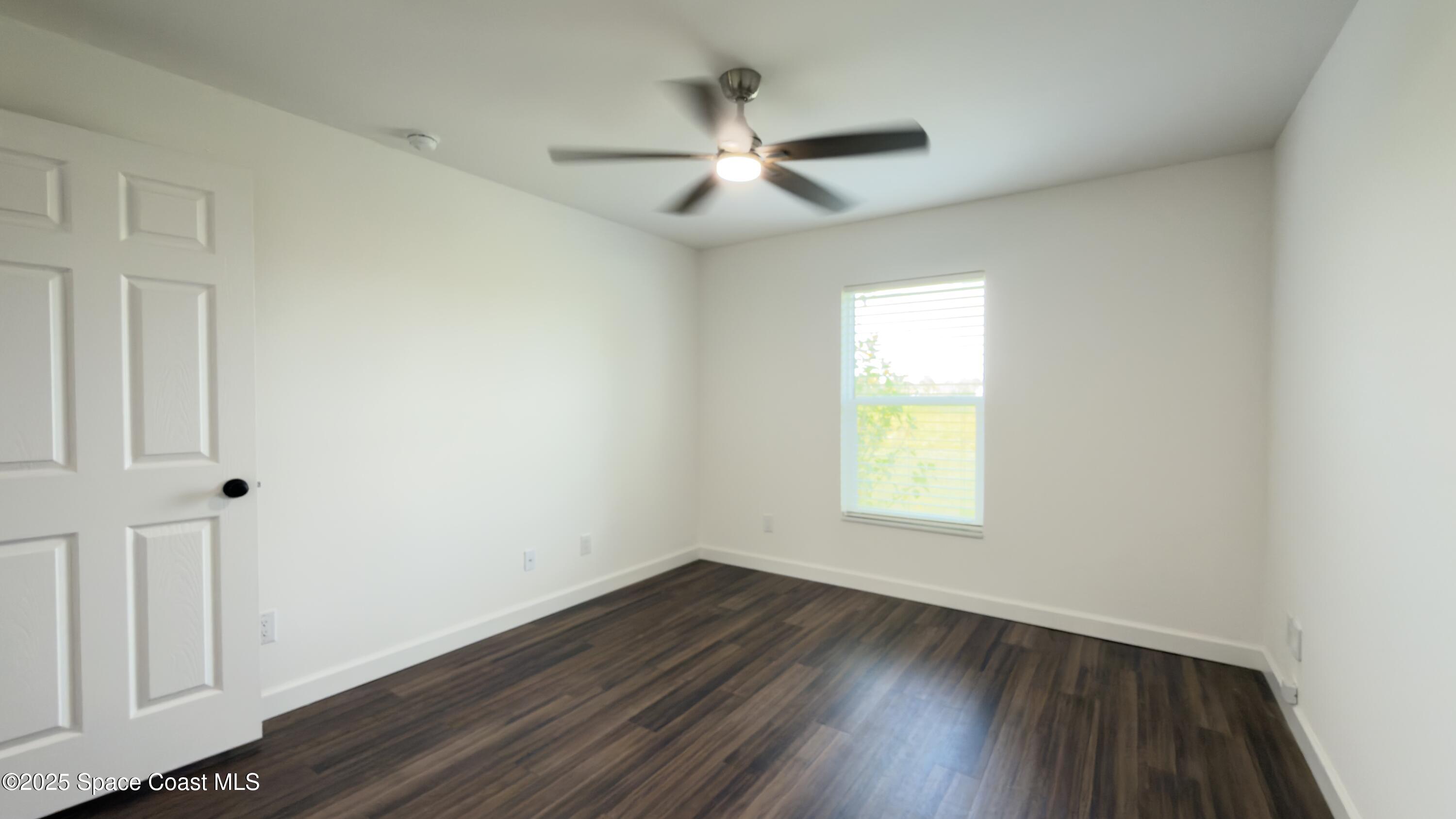 1837 Ardmore Street Northeast Palm Bay, FL 32907 - Photo 20 of 23 a view of an empty room with wooden floor and a window