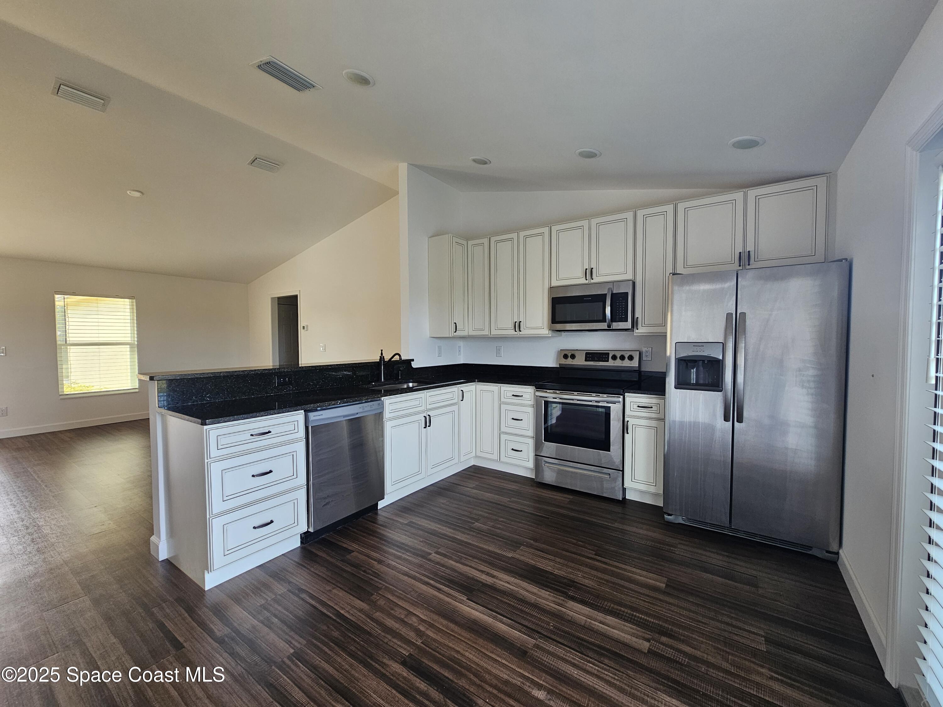 1837 Ardmore Street Northeast Palm Bay, FL 32907 - Photo 6 of 23 a kitchen with stainless steel appliances granite countertop a stove a sink and a refrigerator