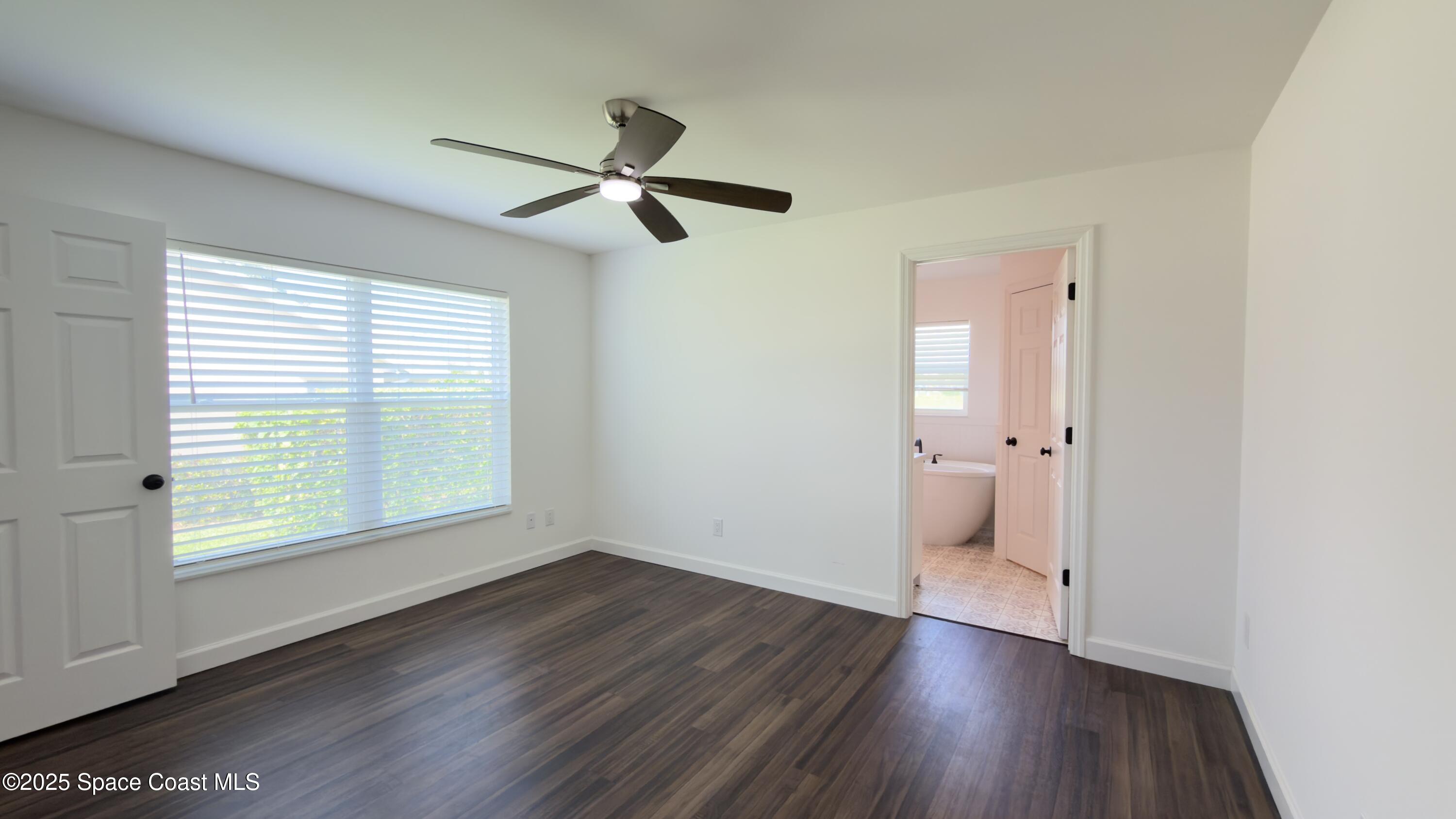 1837 Ardmore Street Northeast Palm Bay, FL 32907 - Photo 8 of 23 a view of a room with wooden floor a ceiling fan and windows
