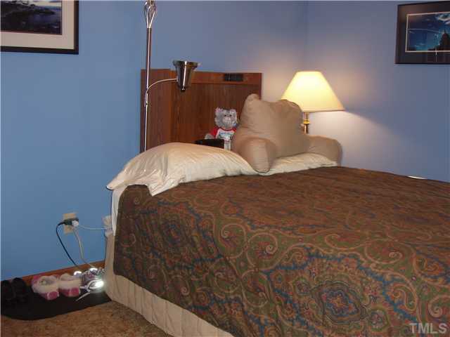 605 Riverview Road Raleigh, NC 27610 - Photo 8 of 19 a bedroom with a bed and a lamp on dresser