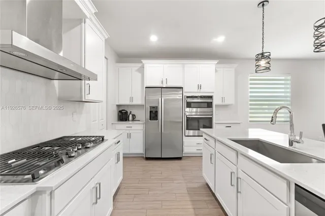a kitchen with a sink stainless steel appliances cabinets and a window