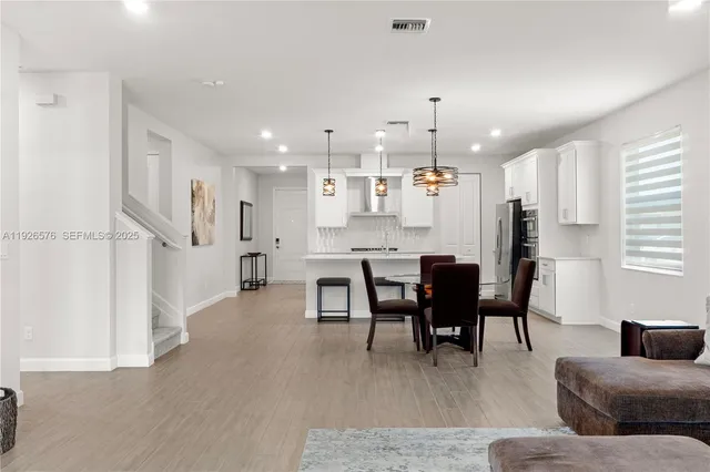 a living room with kitchen island furniture and a chandelier