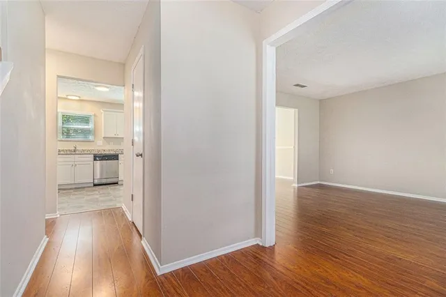 an empty room with wooden floor and a bathroom