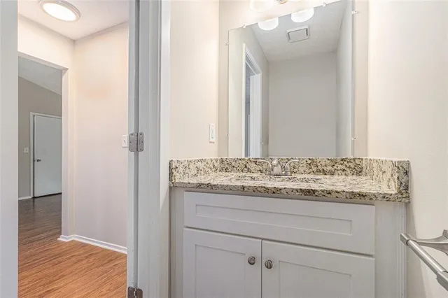 a bathroom with a granite countertop sink and a mirror