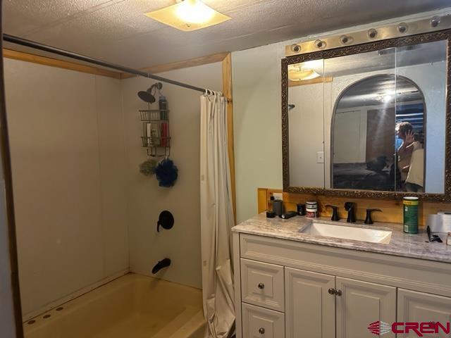 24020 Rd F 5, Unit 5 Cortez, CO 81321 - Photo 4 of 15 a bathroom with a granite countertop sink a mirror a vanity and shower