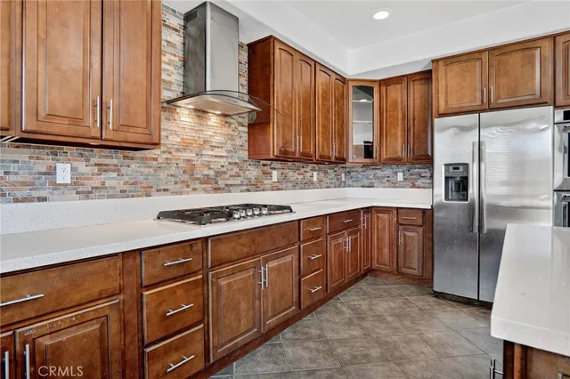 a kitchen with stainless steel appliances granite countertop a refrigerator a sink dishwasher stove and oven