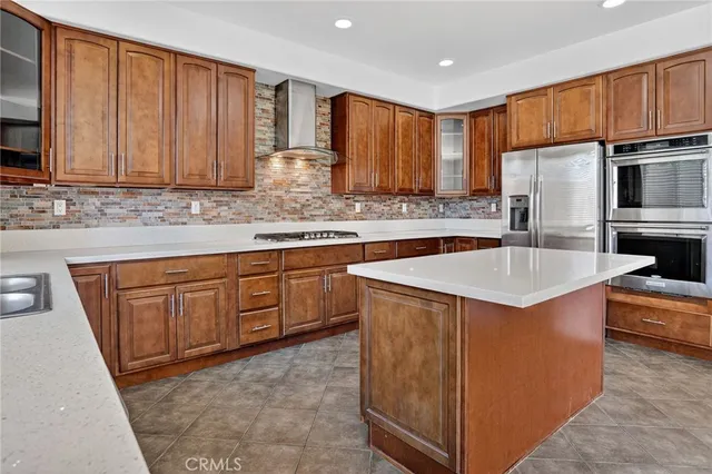 a kitchen with stainless steel appliances granite countertop a sink stove refrigerator and cabinets