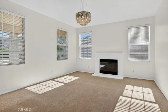 a view of a livingroom with a fireplace a ceiling fan and windows