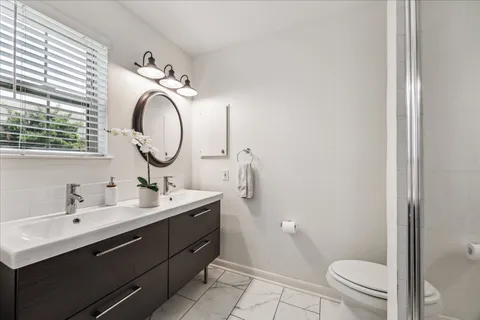 a bathroom with a toilet a sink and mirror