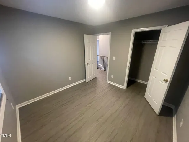 an empty room with wooden floor and entrance