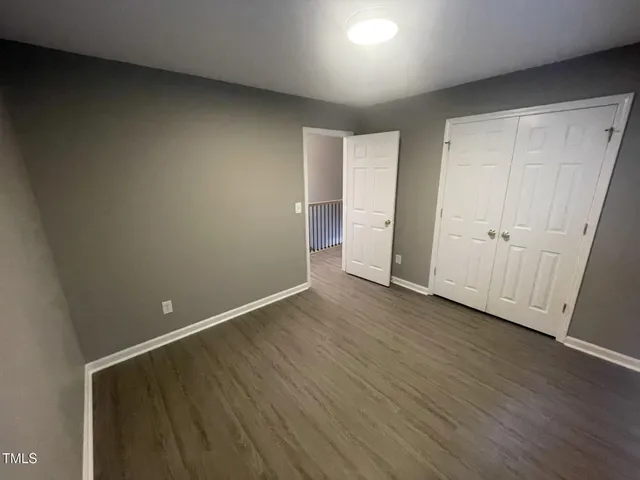a view of an empty room with wooden floor
