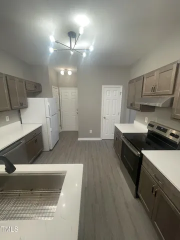 a kitchen with a sink and a stove top oven