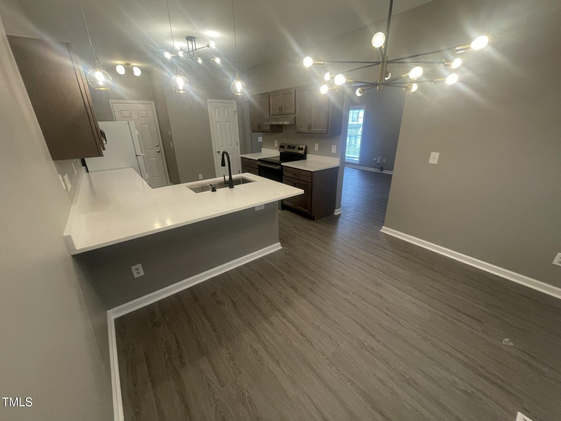 4201 Beacon Crest Way Raleigh, NC 27604 - Photo 8 of 21 a view of a kitchen with a sink and dishwasher a refrigerator with wooden floor