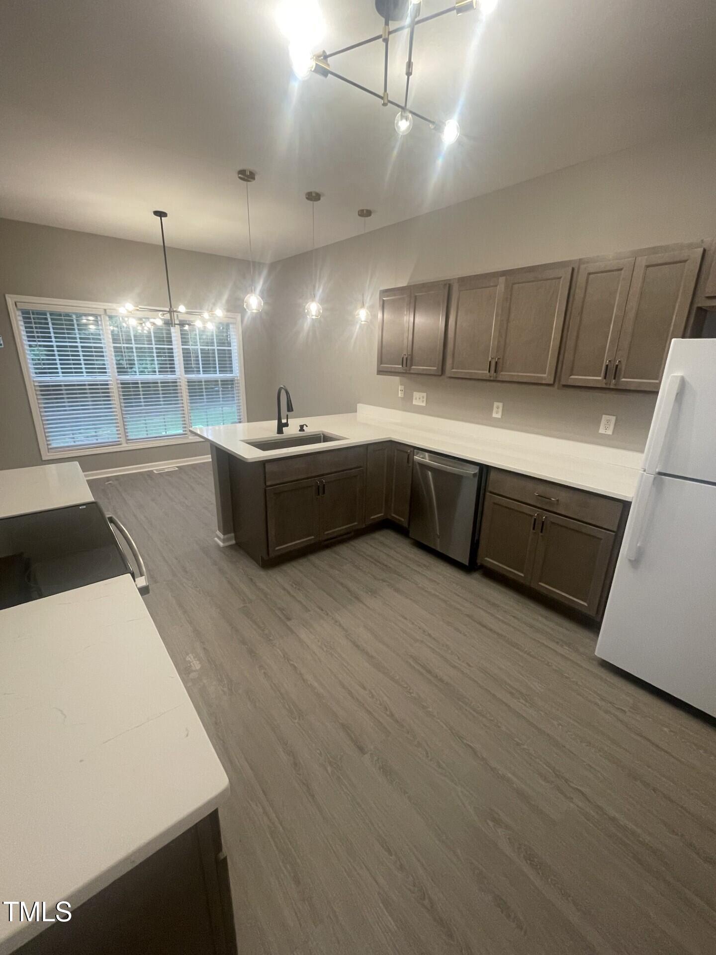 4201 Beacon Crest Way Raleigh, NC 27604 - Photo 9 of 21 a large kitchen with kitchen island a sink dishwasher a stove a dining table and chairs with wooden floor