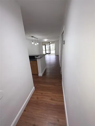 a view of a hallway with wooden floor