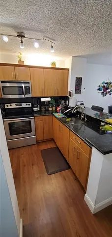 a kitchen with stainless steel appliances a stove a sink and a refrigerator