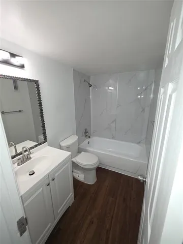 a bathroom with a granite countertop sink a toilet and shower