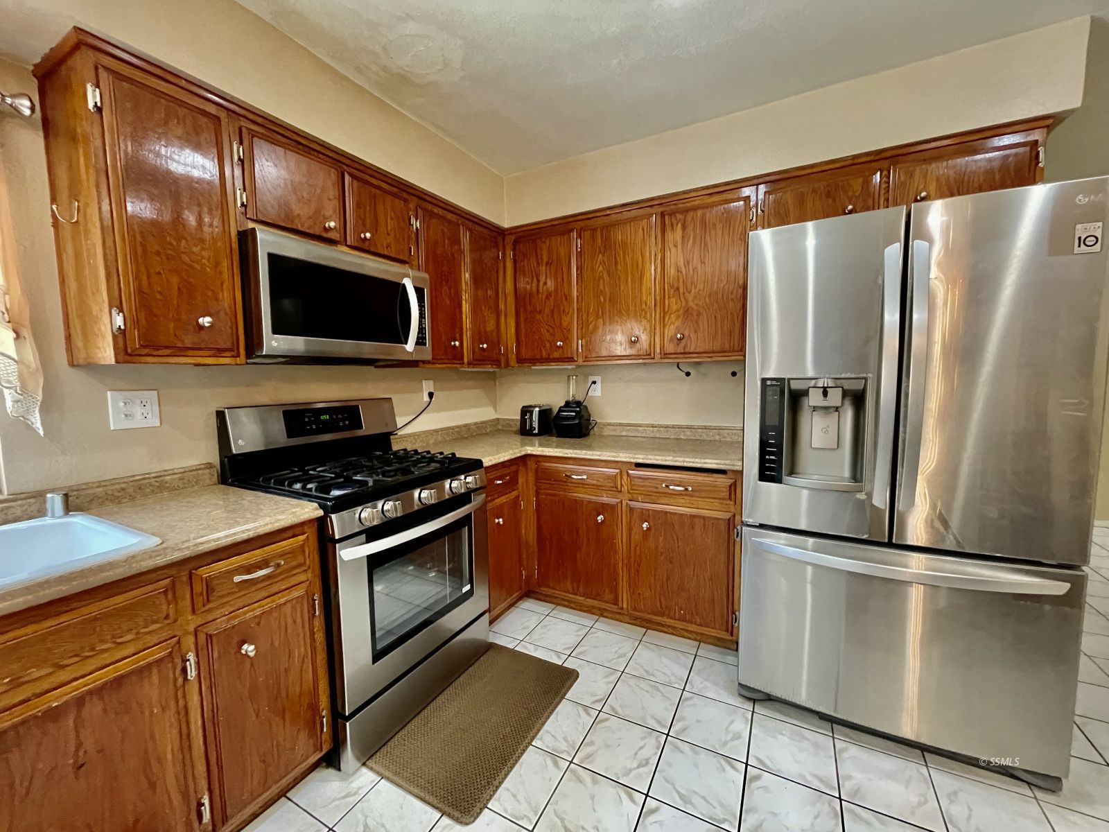 233 West St George Avenue Ridgecrest, CA 93555 - Photo 20 of 47 a kitchen with stainless steel appliances granite countertop a refrigerator stove and microwave