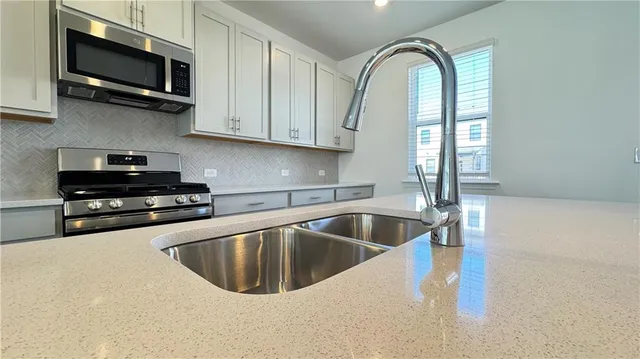 a kitchen with stainless steel appliances white cabinets and a sink