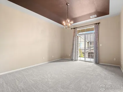 a view of an empty room with a chandelier fan