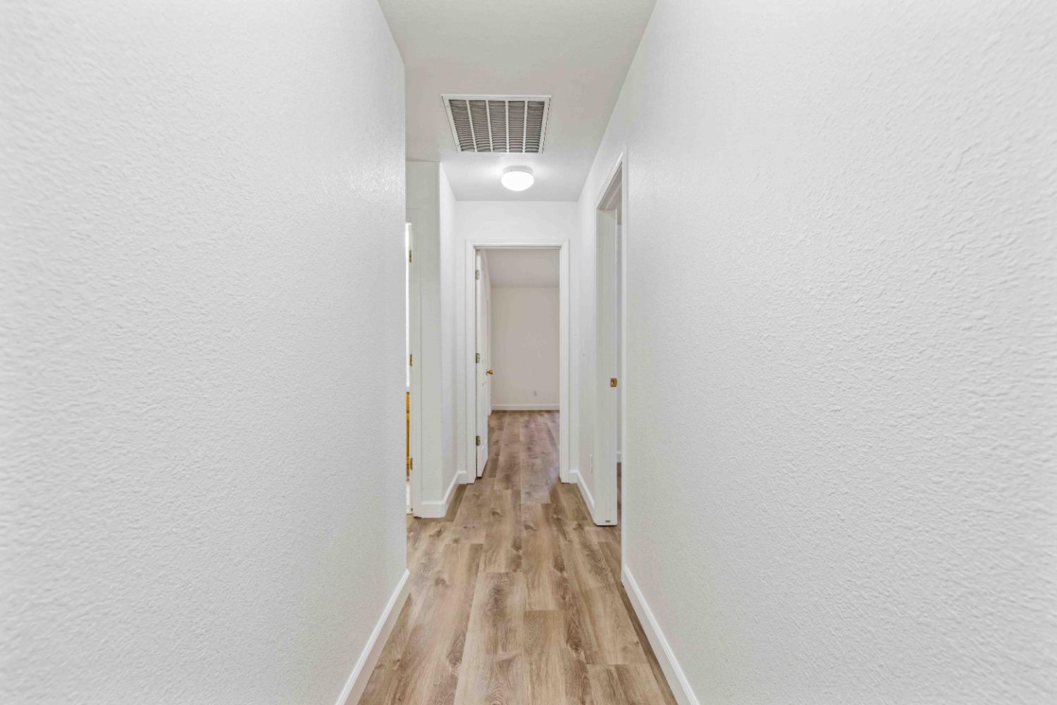995 West Springer Drive Turlock, CA 95382 - Photo 16 of 39 a view of a hallway with wooden floor