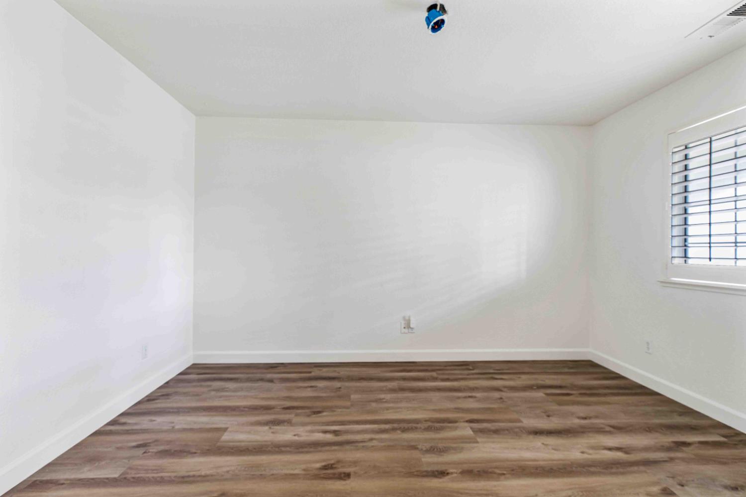 995 West Springer Drive Turlock, CA 95382 - Photo 7 of 39 a view of an empty room with wooden floor and a window