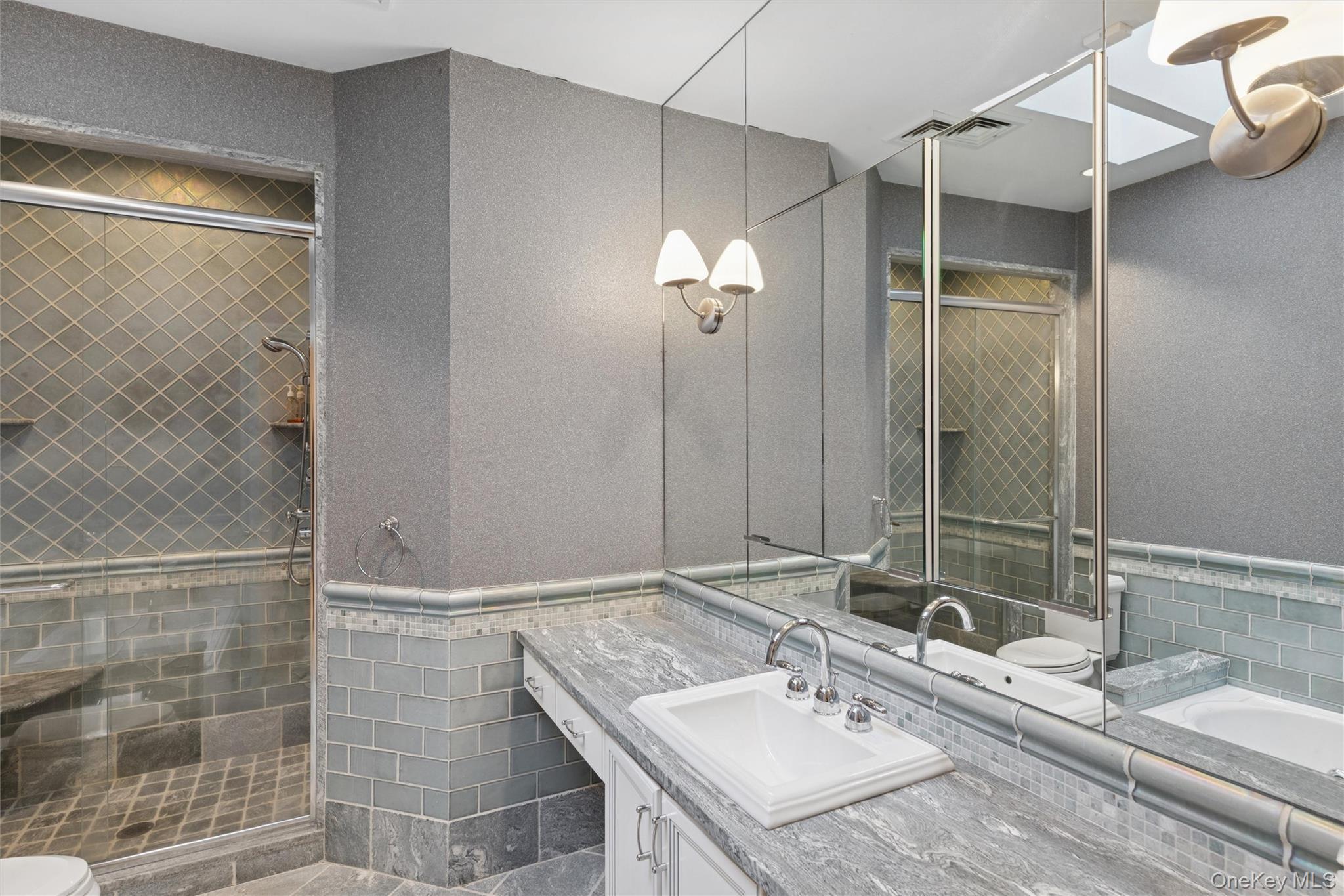 22 Willow Road Woodmere, NY 11598 - Photo 13 of 27 a bathroom with a sink and a mirror