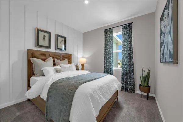 a bedroom with a bed and a potted plant