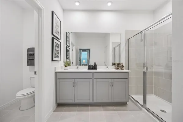 a spacious bathroom with a granite countertop sink a toilet and a mirror