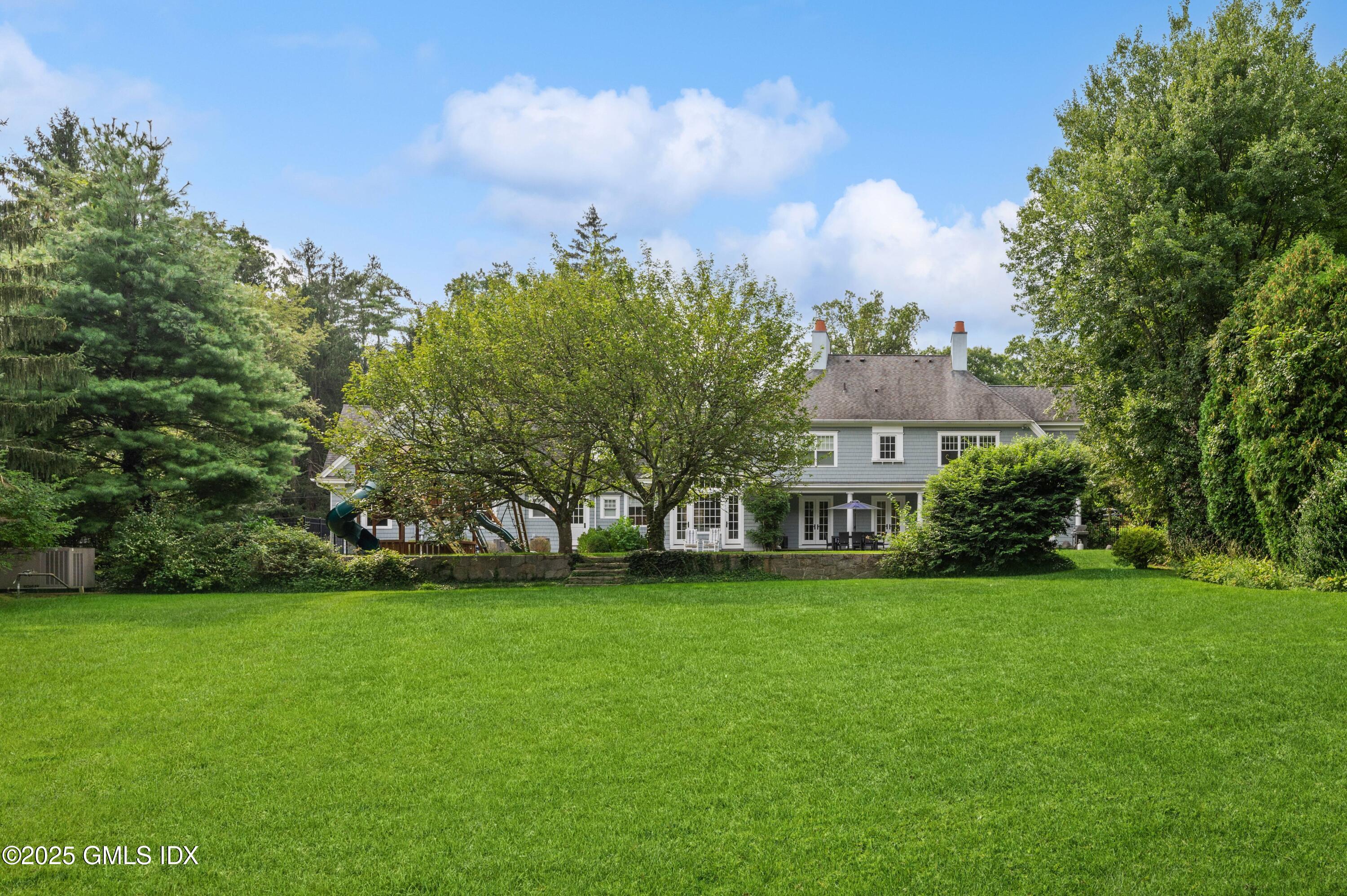 2 Sparrow Lane Greenwich, CT 06830 - Photo 25 of 28 a view of a house with a big yard and large trees
