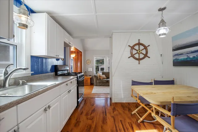 a kitchen with stainless steel appliances granite countertop a sink stove and wooden floor