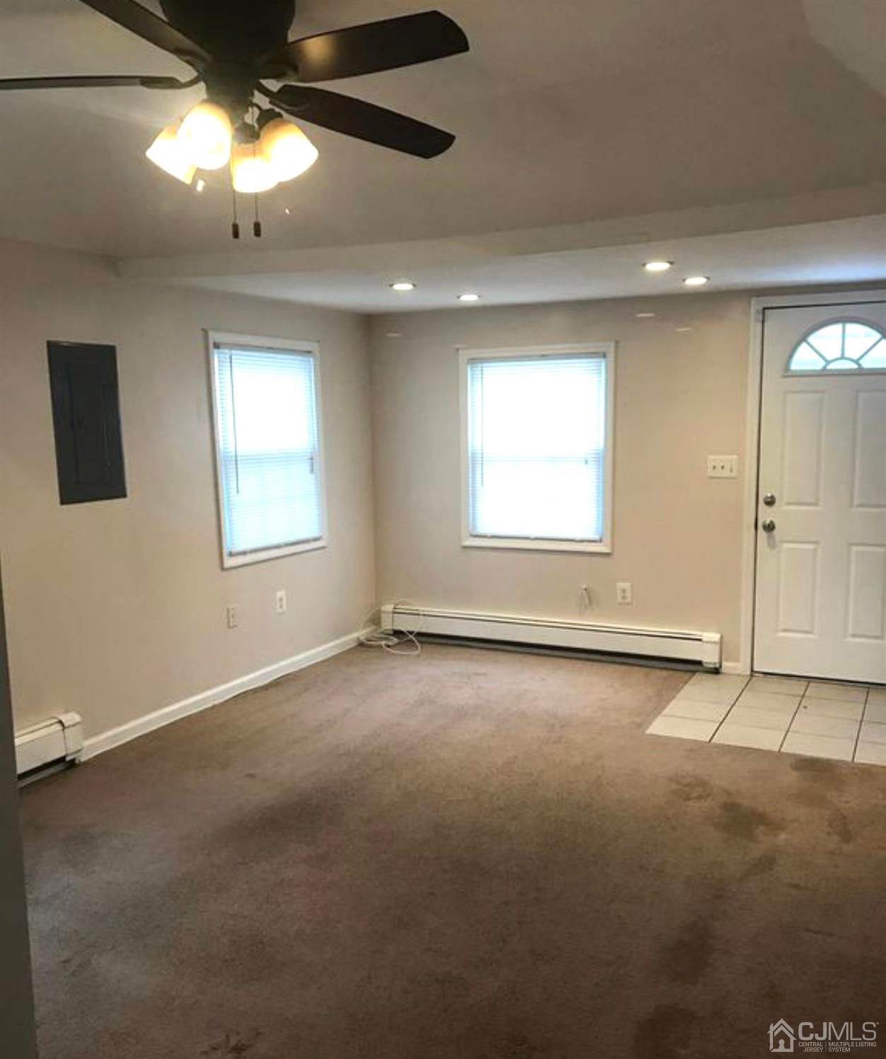 638 Spruce Road North Brunswick, NJ 08902 - Photo 3 of 13 an empty room with windows and chandelier fan