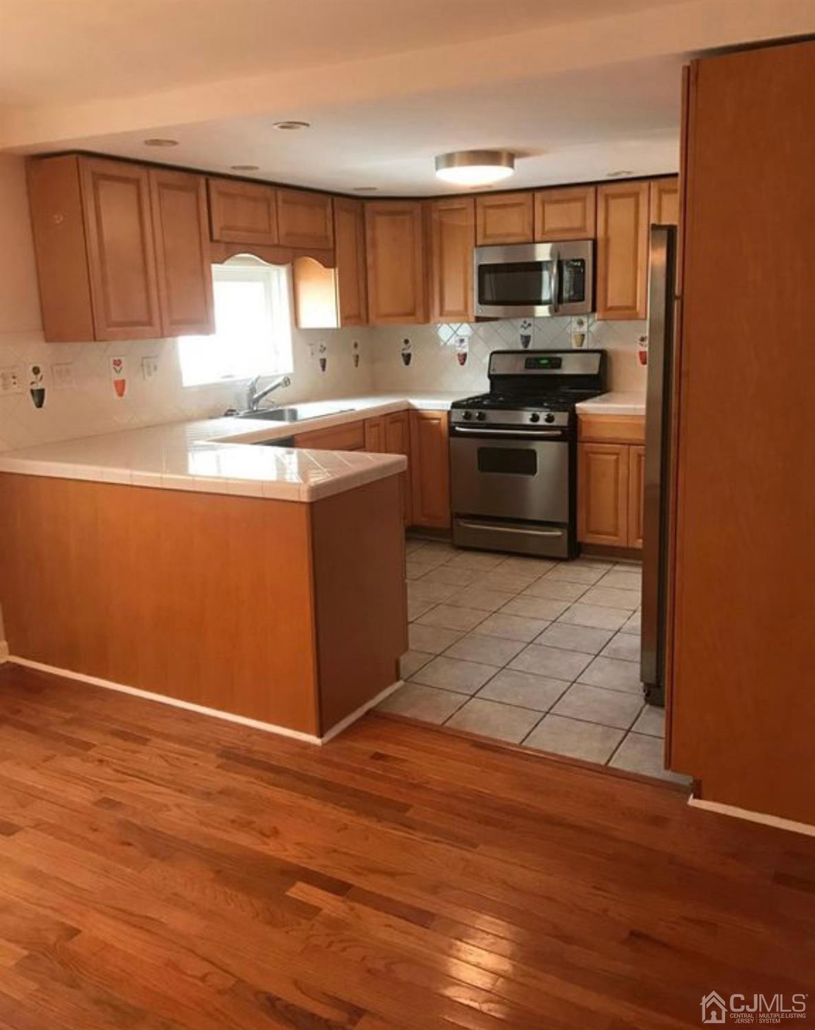 638 Spruce Road North Brunswick, NJ 08902 - Photo 4 of 13 a kitchen with stainless steel appliances granite countertop a stove a sink and a refrigerator