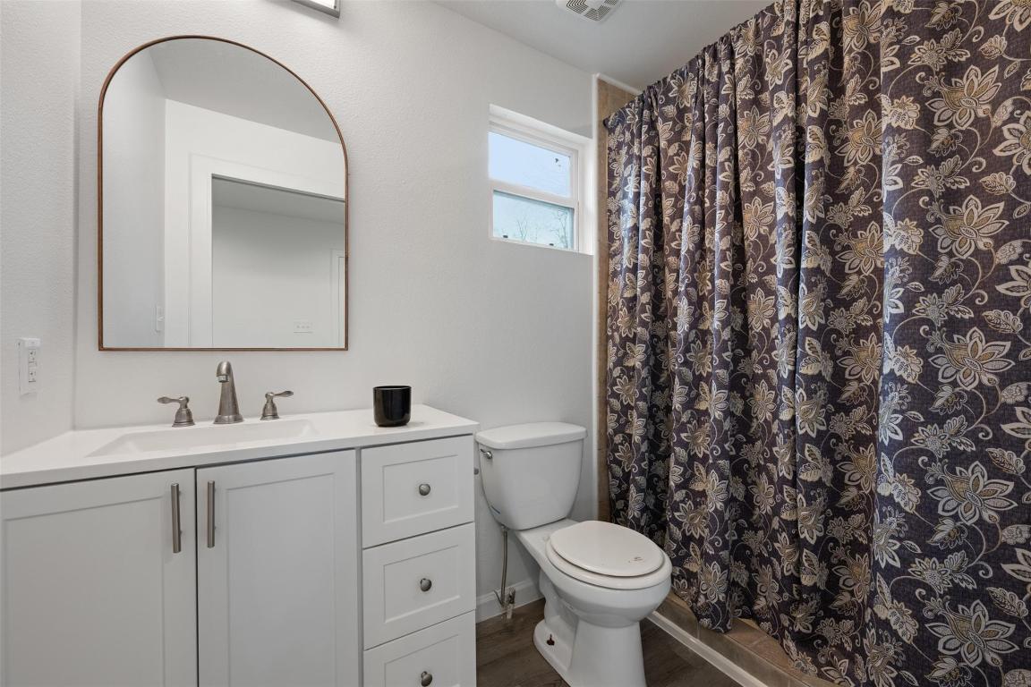 901 Valdez Street, Unit C Austin, TX 78741 - Photo 7 of 12 a bathroom with a toilet sink and mirror