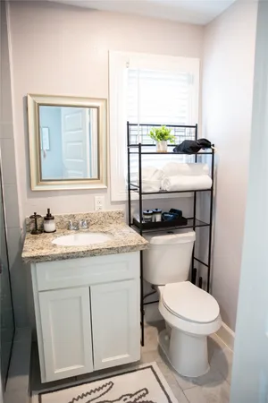 a bathroom with a granite countertop shower a sink and a mirror