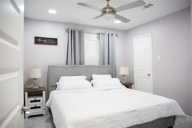 a bedroom with a bed tv and a window