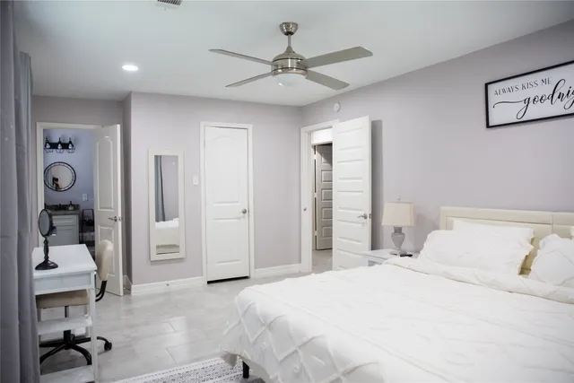 a view of a bedroom with a bed and mirror