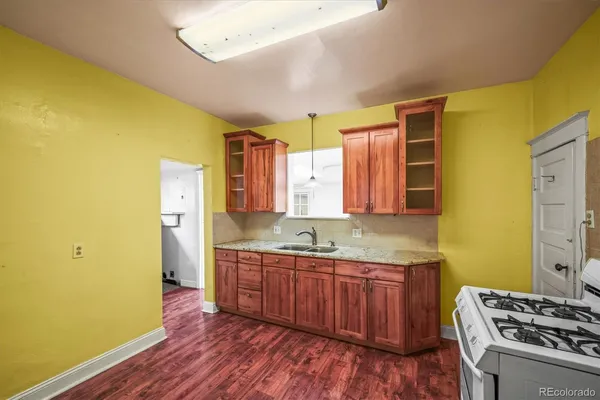 a kitchen with stainless steel appliances granite countertop a sink cabinets and wooden floor