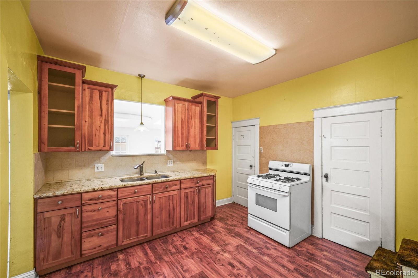4551 Utica Street Denver, CO 80212 - Photo 12 of 32 a kitchen with a stove a sink and a refrigerator