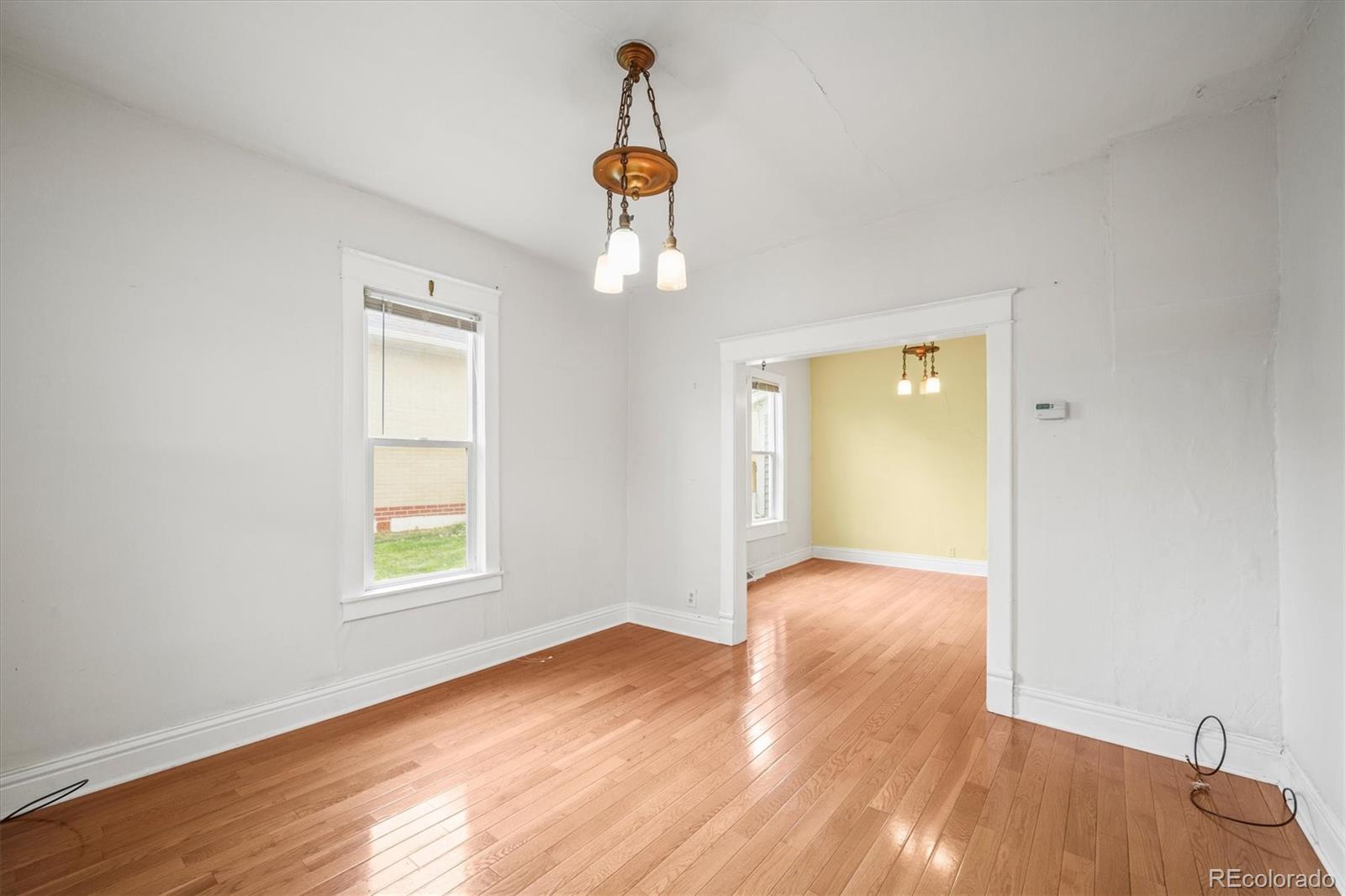4551 Utica Street Denver, CO 80212 - Photo 6 of 32 an empty room with wooden floor cabinet and windows