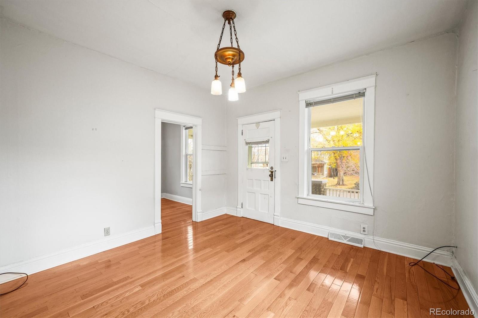 4551 Utica Street Denver, CO 80212 - Photo 7 of 32 an empty room with wooden floor cabinet and windows